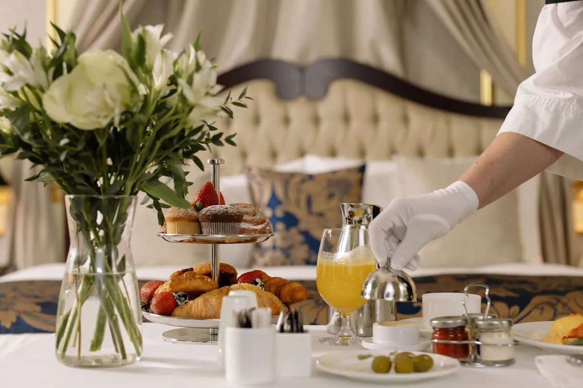 BookNoFees exempelbild: Frukostbord med bakverk, blommor och upphälld apelsinjuice
