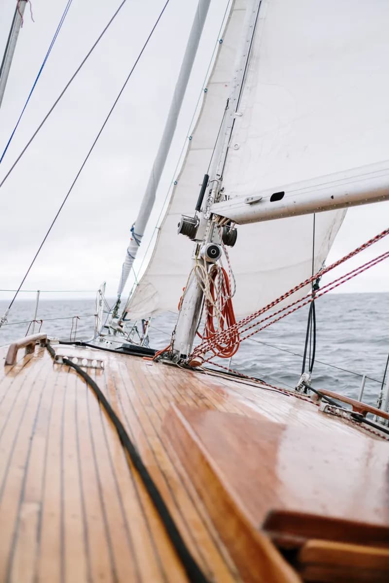 BookNoFees exempelbild: Trädäck på en segelbåt med rep och vitt segel