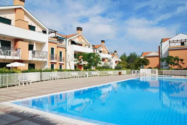 BookNoFees: semesterboende i Cavallino-Treporti, Italien – en stor pool framför en byggnad som tillhör Sunny Apartment On The Sea i Cavallino-Treporti