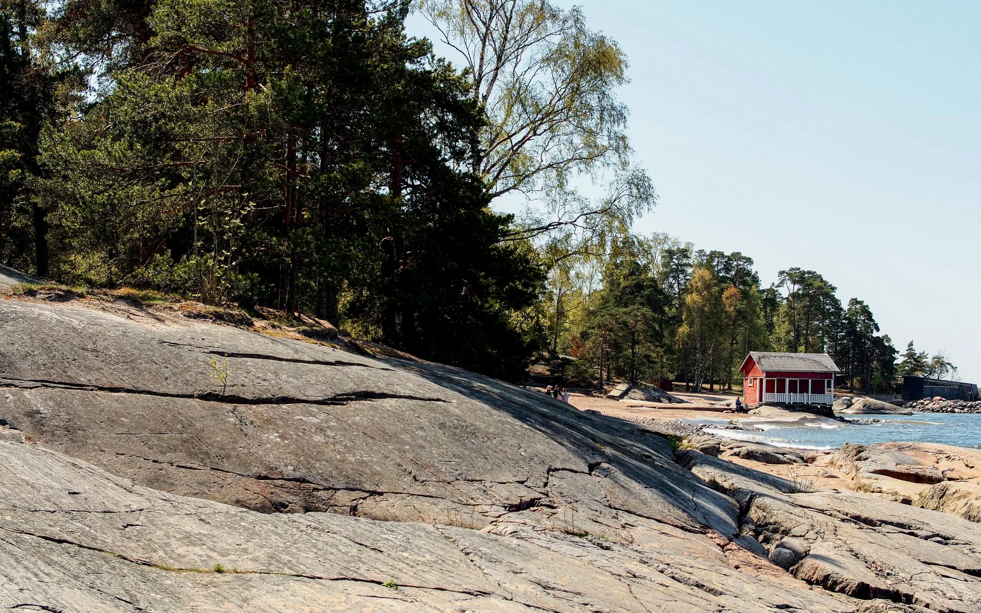 Punainen mökki Helsingin kallioisella rannikolla