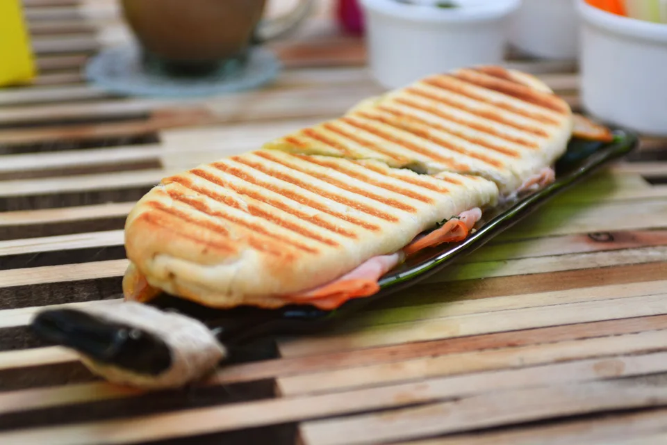 BookNoFees: Exempelbild: En rostad panini med grillmärken på en mörk tallrik